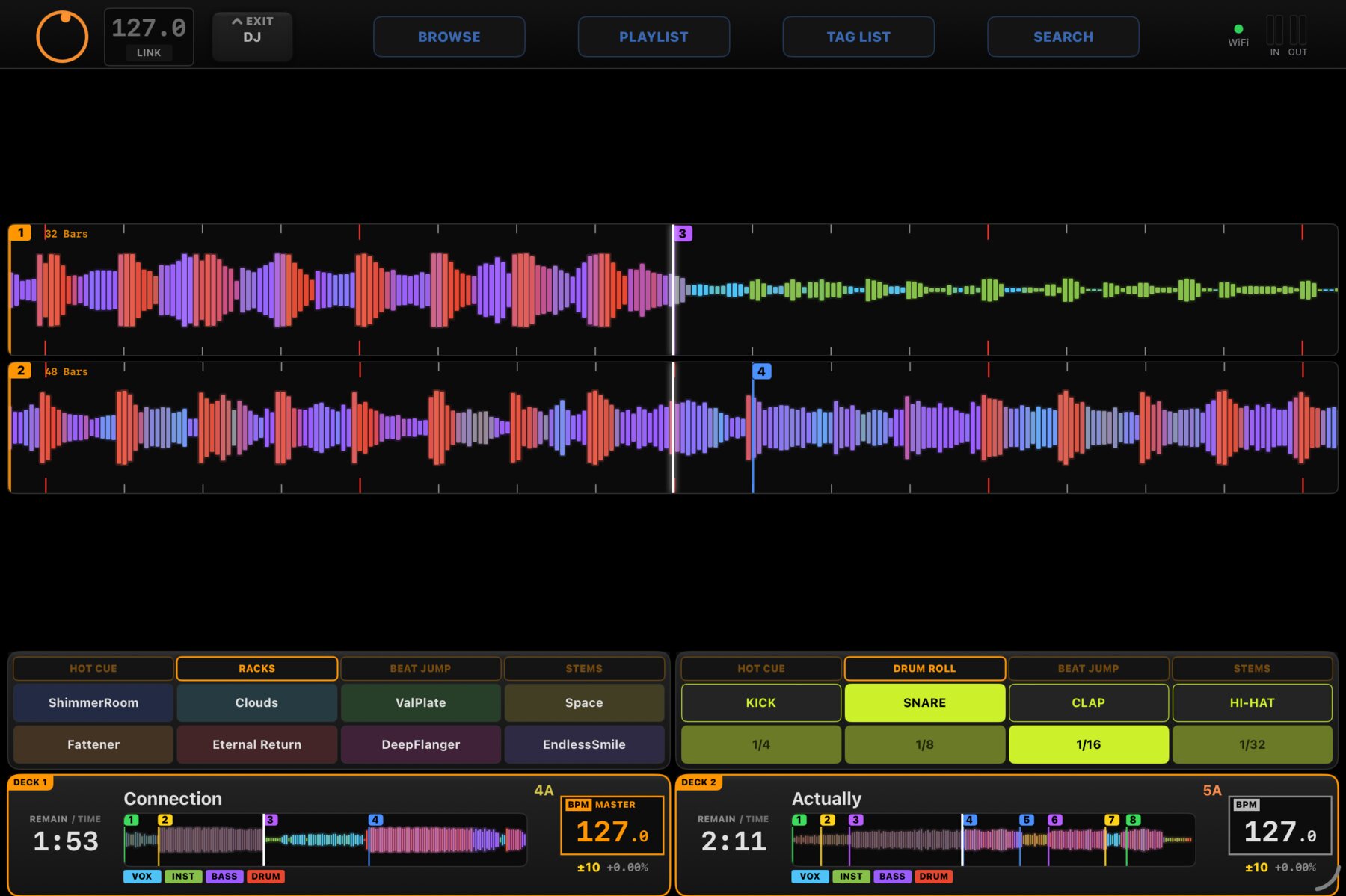 The same two decks on the iPad: full-width scrolling waveforms with hot cue markers, rack launch pads and drum-roll pads, both decks synced at 127.